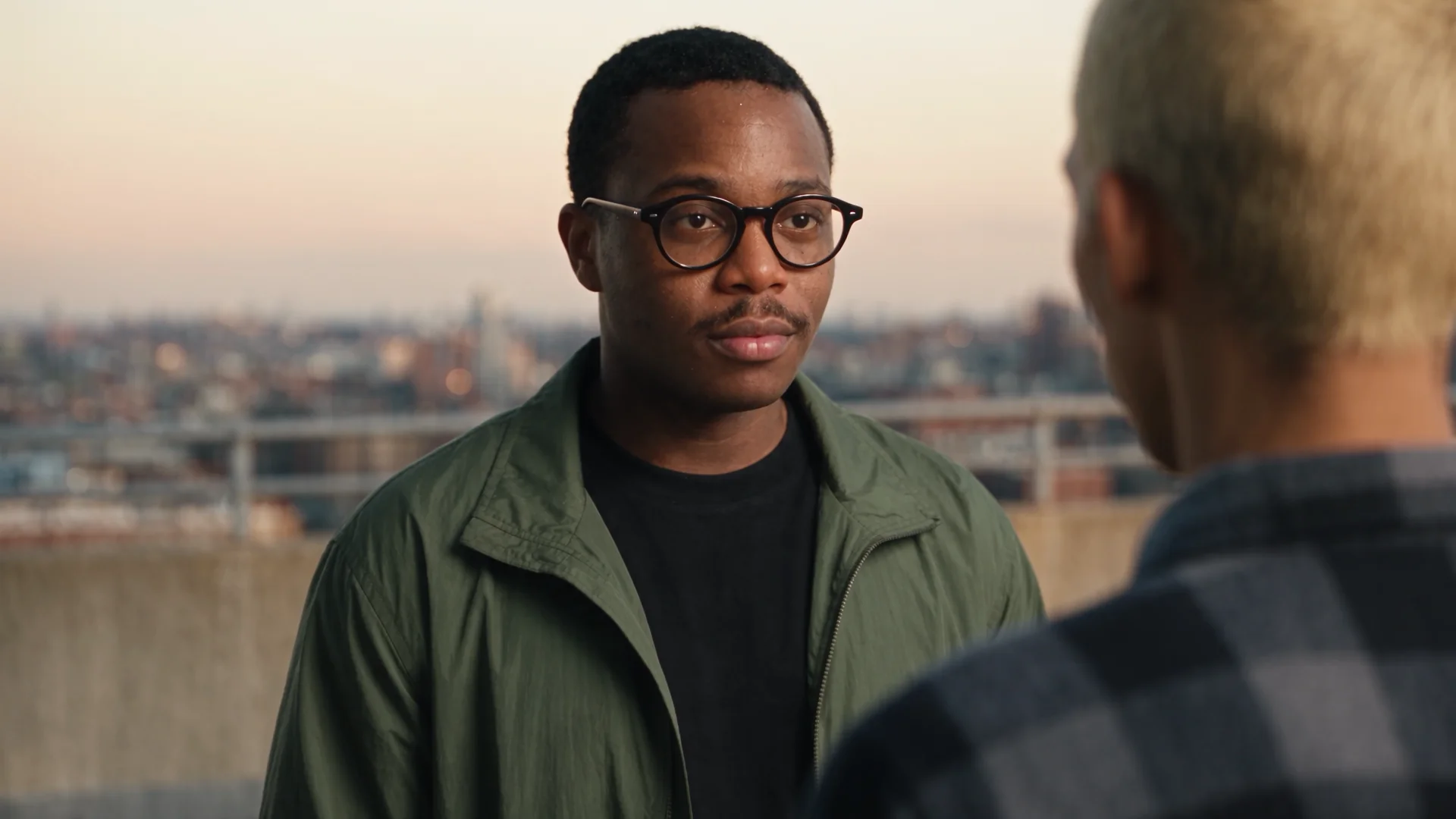 Over-the-shoulder shot favoring the man in glasses